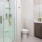 Bathroom with glass shower with build-in shelving, wooden vanity and large mirror