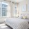Master bedroom with oversized windows, queen-sized bed, wall art and gold lamp