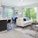 Living room with patio, oversized windows, seating, accent rug, and kitchen bar with stools