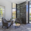 Sitting area and leasing office with leasing consultant sitting at her desk. Floor-to-ceiling windows with a view to the courtyard.